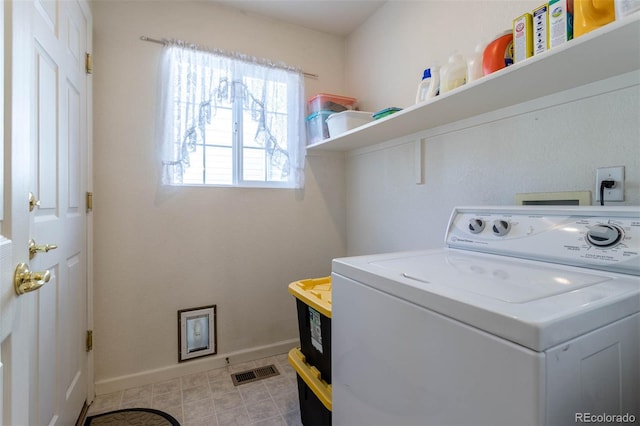 clothes washing area with washer / dryer and light tile patterned floors