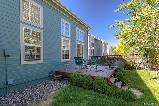 rear view of property featuring a deck and a yard