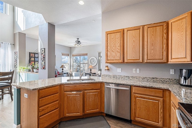 kitchen featuring light stone countertops, appliances with stainless steel finishes, sink, and kitchen peninsula