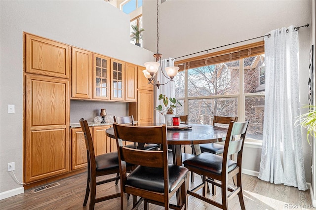 dining area featuring hardwood / wood-style flooring and an inviting chandelier