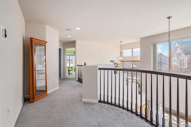 hallway with a wealth of natural light and carpet flooring