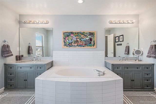 bathroom with vanity and a relaxing tiled tub