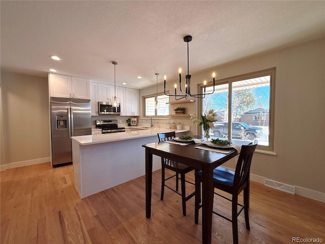 dining room featuring light hardwood / wood-style floors and a notable chandelier