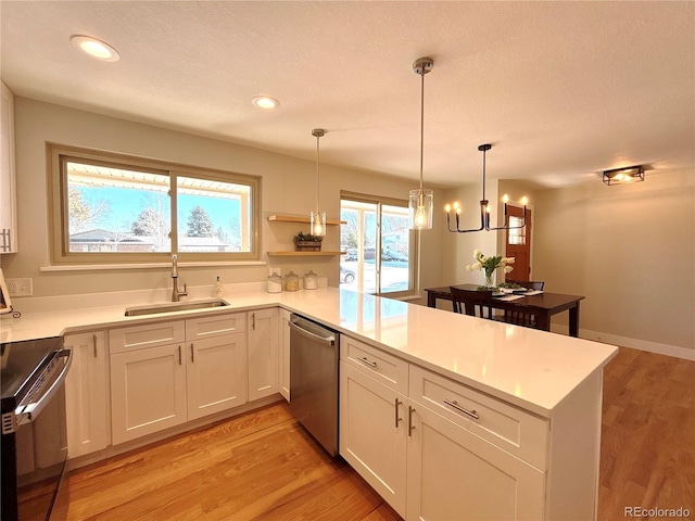 kitchen featuring dishwasher, kitchen peninsula, white cabinetry, and sink