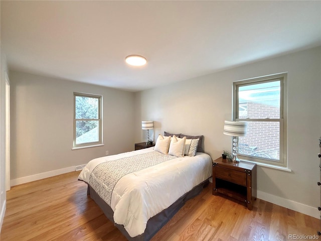 bedroom featuring light wood-type flooring and multiple windows