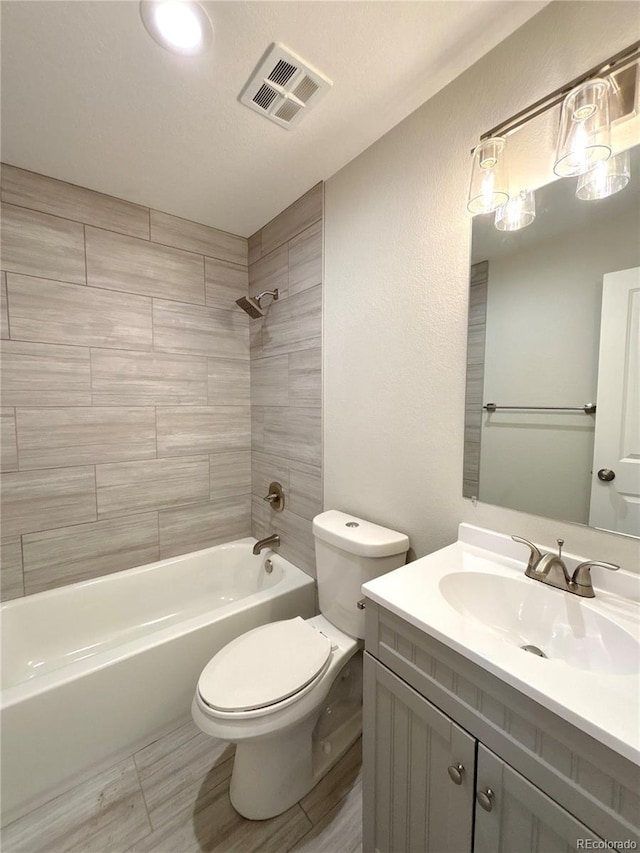 full bathroom featuring vanity, toilet, and tiled shower / bath combo