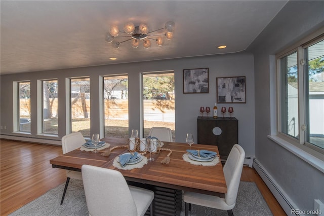 dining space featuring a baseboard heating unit, recessed lighting, wood finished floors, and baseboards