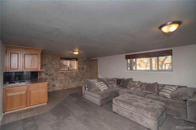 living area featuring a textured ceiling and dark tile patterned flooring