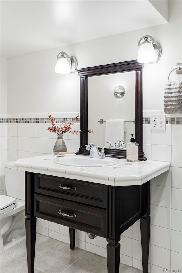 1272 S Milwaukee St, Denver, CO 80210 - bathroom with tile walls, vanity, tile patterned floors, and a wainscoted wall