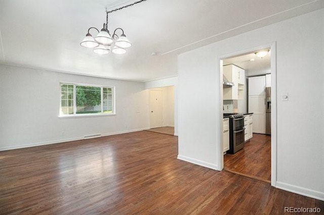 unfurnished living room featuring a notable chandelier and dark wood-type flooring