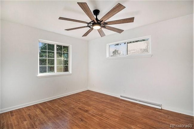 spare room with a healthy amount of sunlight, ceiling fan, a baseboard radiator, and wood-type flooring