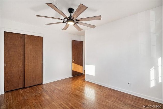 unfurnished bedroom featuring ceiling fan, dark wood-type flooring, and a closet