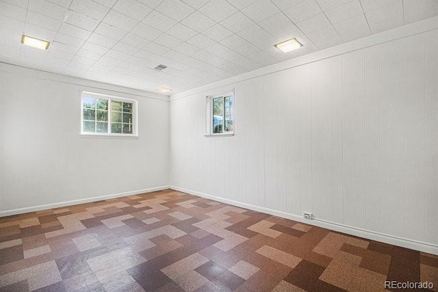 basement featuring crown molding and plenty of natural light