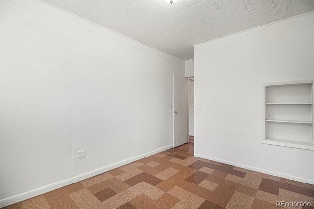 empty room featuring carpet floors and ornamental molding