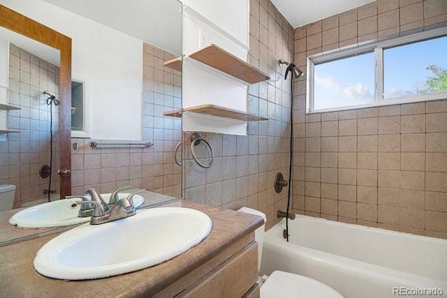 full bathroom with vanity, tiled shower / bath combo, and toilet