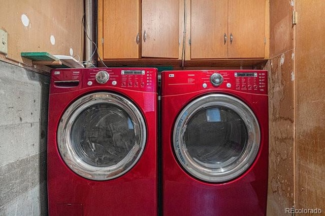 washroom featuring cabinets and washer and clothes dryer