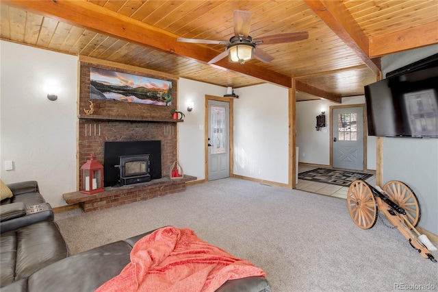 952 Burland Dr, Bailey, CO 80421 - carpeted living area featuring wooden ceiling with exposed beams, a wood stove, a ceiling fan, and baseboards