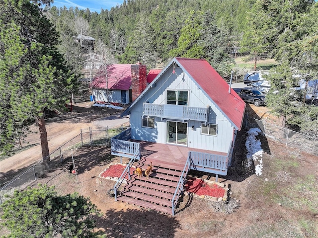 952 Burland Dr, Bailey, CO 80421 - view of front facade featuring a wooden deck, a wooded view, a chimney, and a balcony