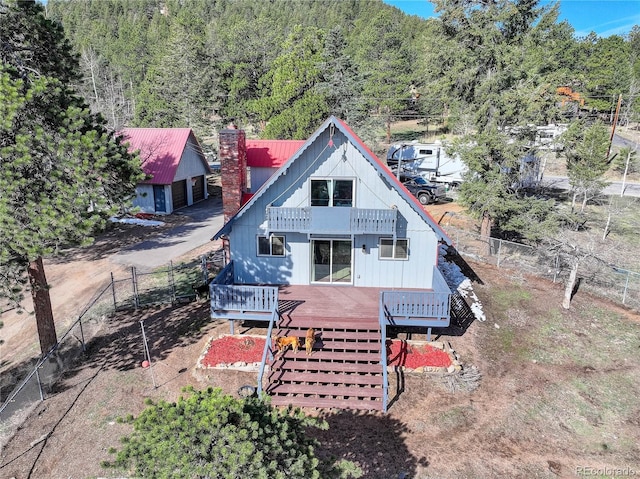 952 Burland Dr, Bailey, CO 80421 - rear view of property featuring a balcony, a deck, a chimney, and a view of trees