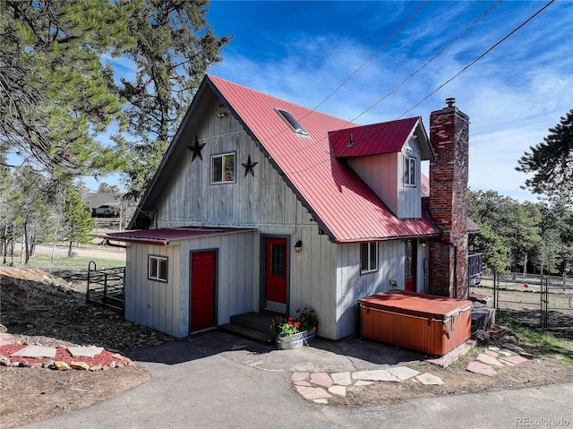 952 Burland Dr, Bailey, CO 80421 - chalet / cabin featuring a hot tub, a chimney, and metal roof
