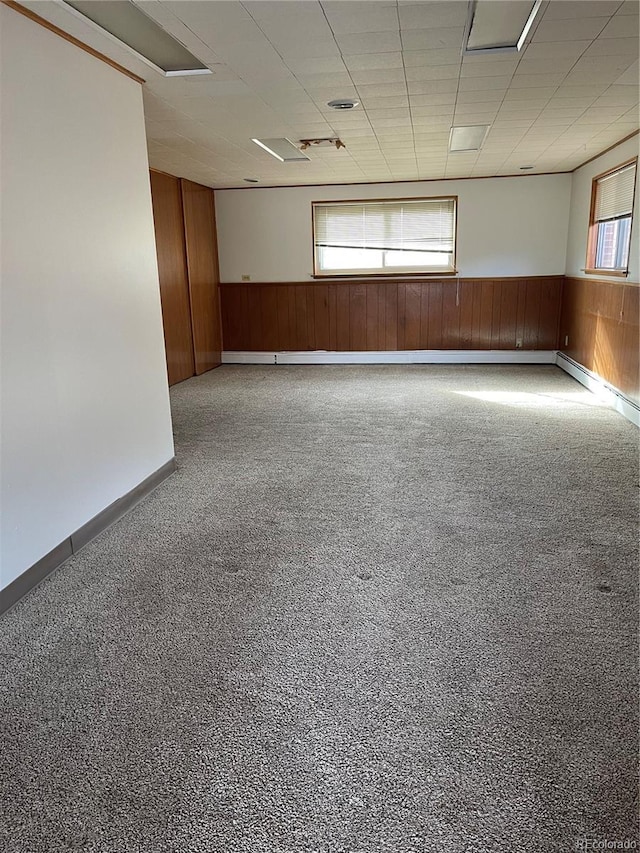 spare room featuring a drop ceiling and wood walls