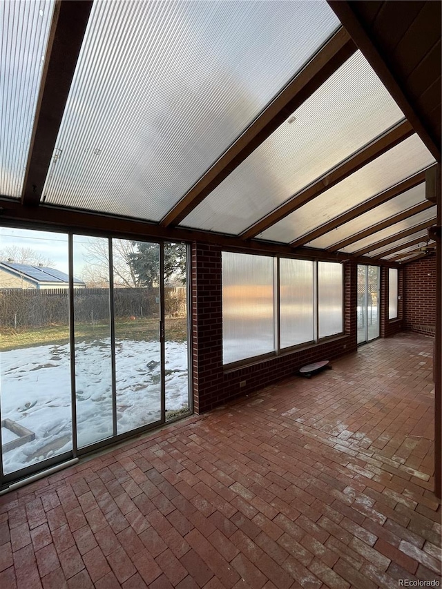 unfurnished sunroom with beam ceiling