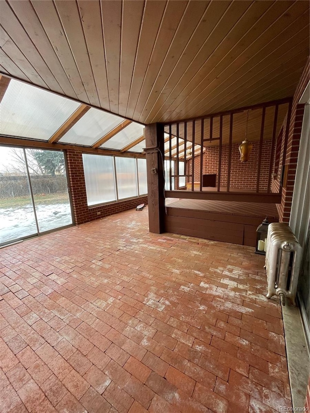 unfurnished sunroom featuring wood ceiling and radiator heating unit