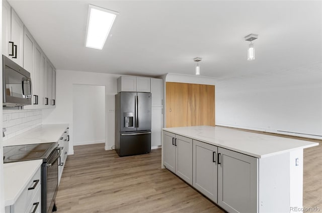 4731 W 66th Ave, Arvada, CO 80003 - kitchen featuring appliances with stainless steel finishes, light wood finished floors, gray cabinets, and light countertops