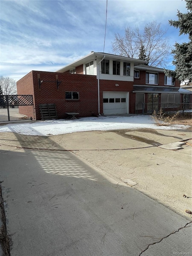 4731 W 66th Ave, Arvada, CO 80003 - view of front facade featuring brick siding, a garage, and driveway