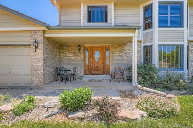 20596 E Shefield Ct, Parker, CO 80138 - view of exterior entry featuring a porch, brick siding, and an attached garage