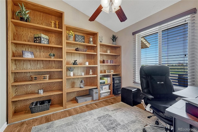 office area featuring wood finished floors, a ceiling fan, and vaulted ceiling