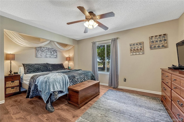 bedroom with light wood-style flooring, a textured ceiling, baseboards, and a ceiling fan