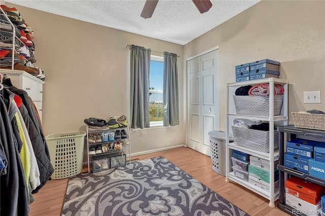 interior space with a textured ceiling, wood finished floors, and ceiling fan