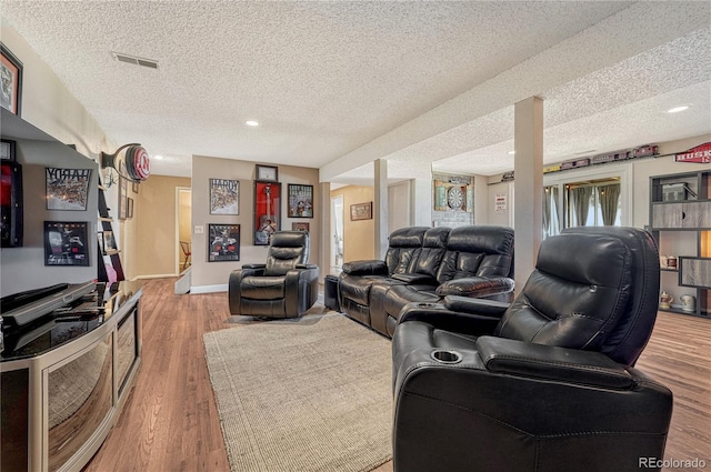 living area featuring visible vents, baseboards, a textured ceiling, recessed lighting, and wood finished floors