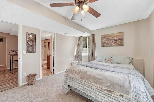 carpeted bedroom with baseboards, connected bathroom, ceiling fan, and a textured ceiling