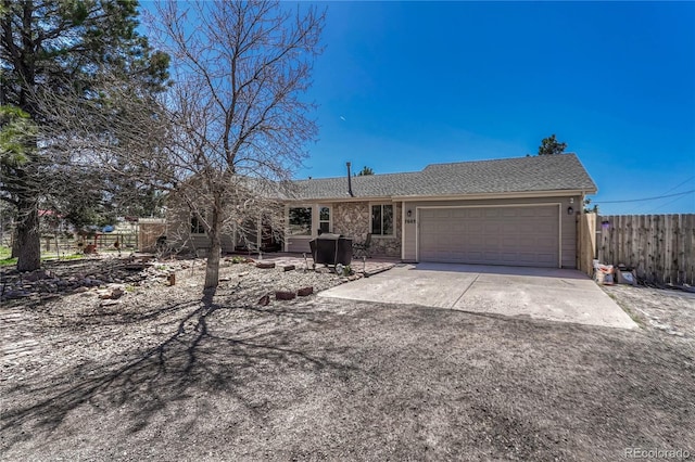 ranch-style home featuring concrete driveway, a garage, fence, and roof with shingles