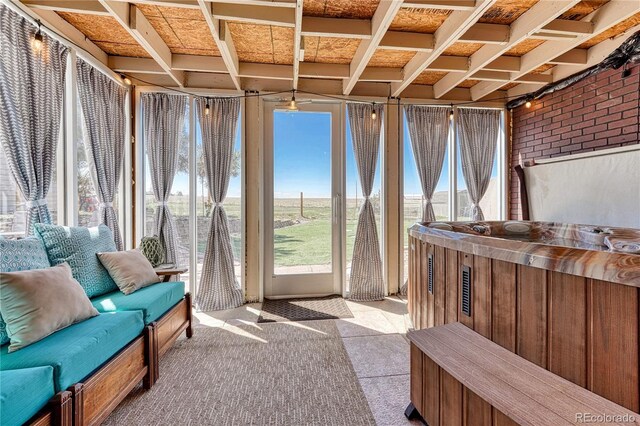 sunroom / solarium with carpet, brick wall, and a hot tub