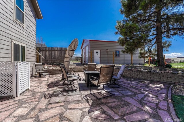 view of patio featuring outdoor dining area and fence