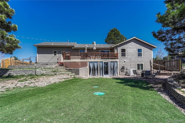 back of property featuring a yard, a deck, a patio area, and fence