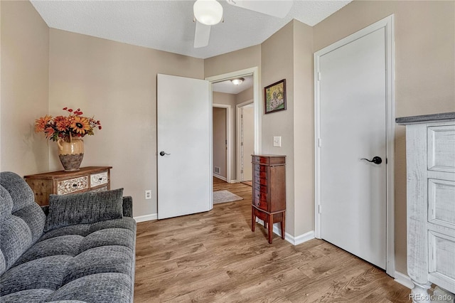 interior space featuring visible vents, light wood-type flooring, baseboards, and ceiling fan