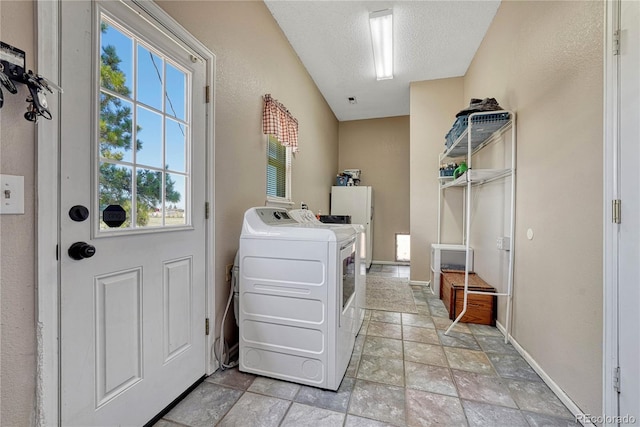 laundry room with stone tile flooring, washing machine and clothes dryer, laundry area, and a healthy amount of sunlight