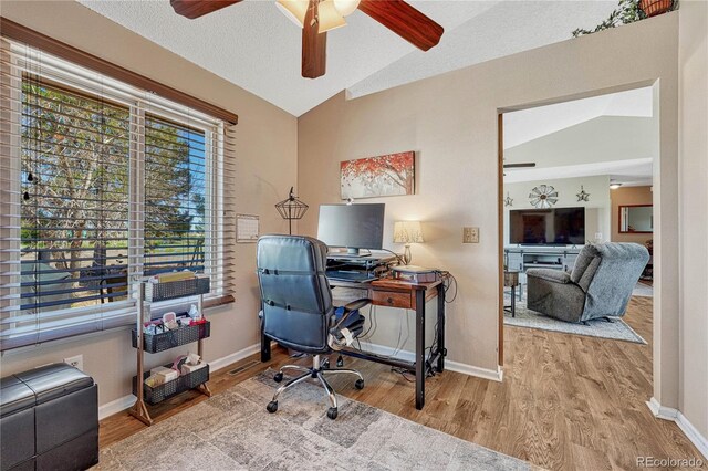 office area featuring wood finished floors, ceiling fan, baseboards, and vaulted ceiling
