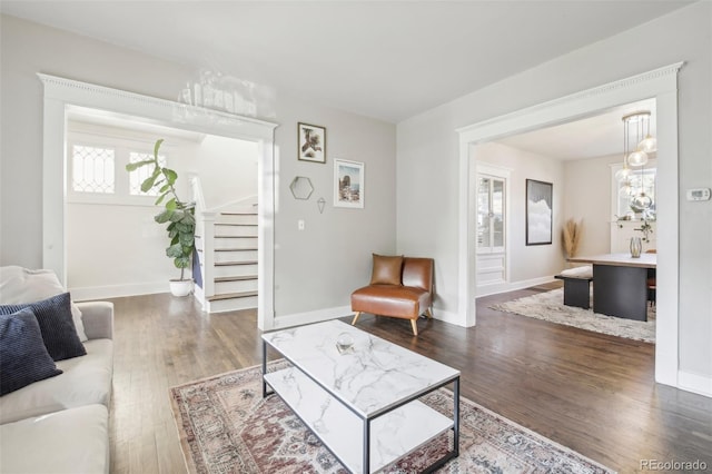 living room featuring stairs, wood finished floors, and baseboards