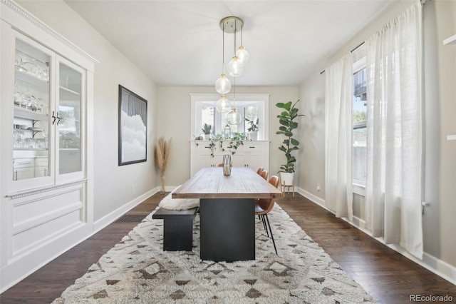 dining room featuring dark wood-style floors and baseboards
