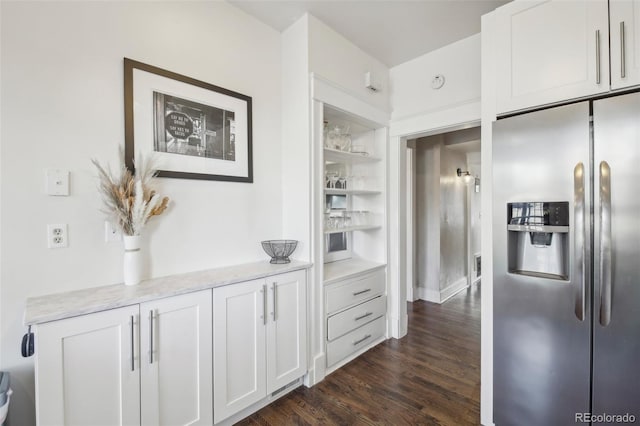 kitchen featuring stainless steel fridge with ice dispenser, white cabinets, dark wood-style floors, light stone counters, and open shelves