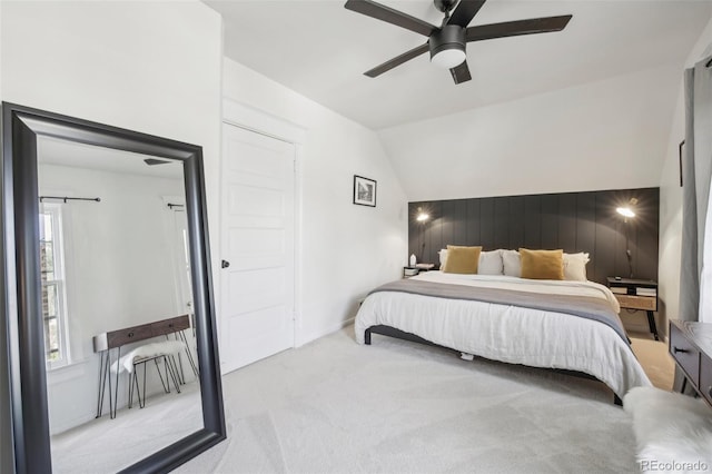 carpeted bedroom with lofted ceiling, a ceiling fan, and wood walls