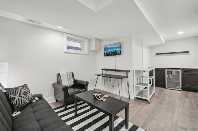 living area featuring wine cooler, wet bar, light wood-style floors, recessed lighting, and baseboards