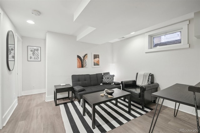 living room with light wood-style floors, baseboards, and recessed lighting