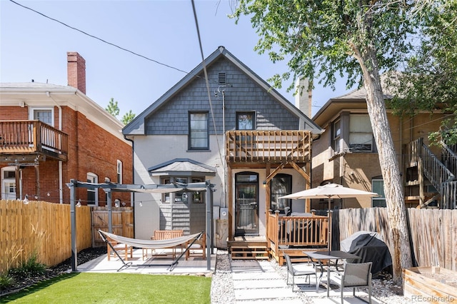 back of property featuring a fenced backyard, a balcony, a patio, and brick siding