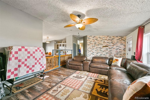 living room with ceiling fan, hardwood / wood-style flooring, a textured ceiling, and vaulted ceiling